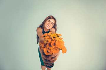 Woman giving wreath of yellow flowers looking to you camera.