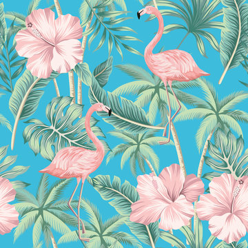 Tropical pink hibiscus and flamingo floral green palm leaves seamless pattern blue background. Exotic jungle wallpaper.