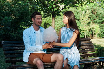young couple sitting on bench in park