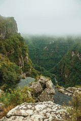 Creek on waterfall edge with steep rocky cliffs