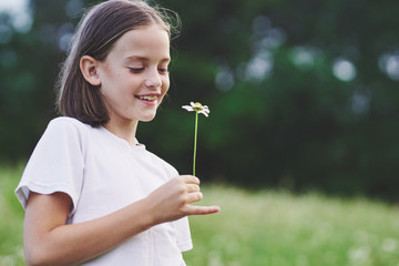 young girl blowing dandelion