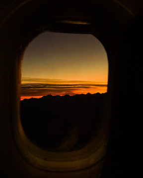 sunset in airplane window in flight