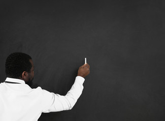 African-American teacher writing on blackboard in classroom