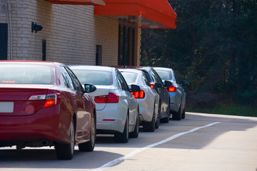 Generic drive thru pickup window with cars waiting in line to get their products or food