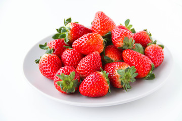 Fresh strawberries on a light grey plate, on a white background