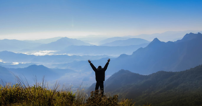 man standing and lift hand on mountain background