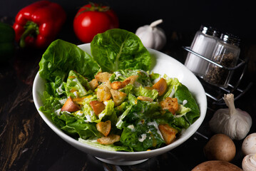 A plated caesar salad with dark background