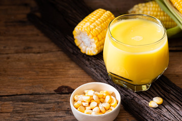 Fresh sweet corn juice (corn milk) and corn on wood background