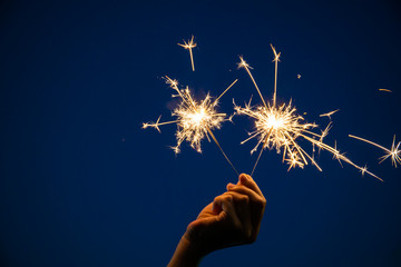 Girl enjoy playing with a small sparkler hand fireworks, celebrating in Christmas and New Year...