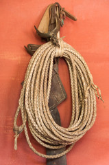 Lasso rope hanging looped on wall hook © Marge