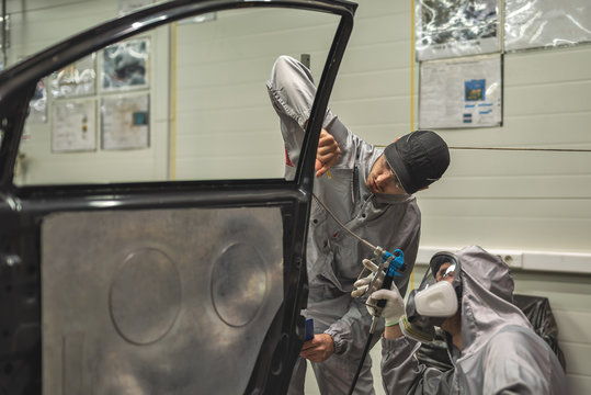 An employee of the paint shop of the automobile plant conducts training on applying sealant