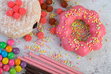 Strawberry and donuts topped with a large amount of icing and topping.