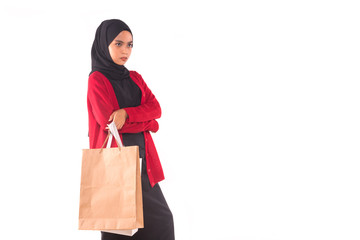 Fototapeta na wymiar Happy young Muslim girl holding shopping bags isolated over white background.