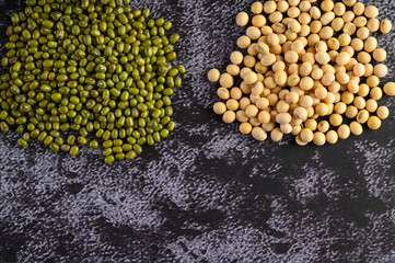 Soybean and Mung bean on a black cement floor background.