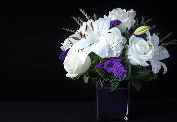 Valentines Day Funeral Bouquet purple White flowers, Sympathy and Condolence Concept on black background with copy space.