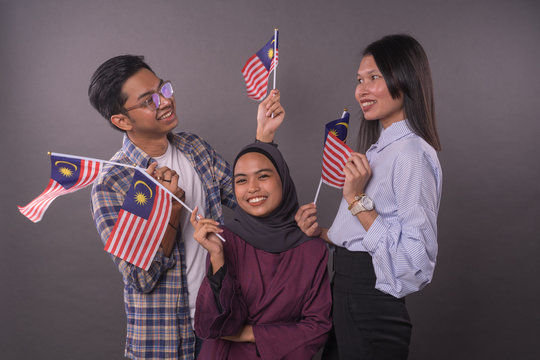 Happy Multi Racial Malaysian People Holding Malaysia Flag.Independence Day And Patriotic Concept.Studio Shot.