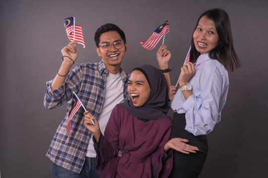 Happy Multi Racial Malaysian People Holding Malaysia Flag.Independence Day And Patriotic Concept.Studio Shot.