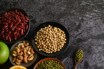 legumes and fruit on a black cement floor background.
