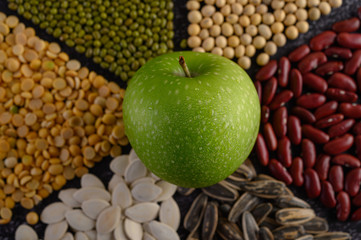 legumes with apple on a black cement floor background.