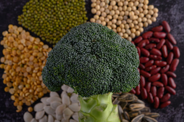 legumes with broccoli on a black cement floor background.
