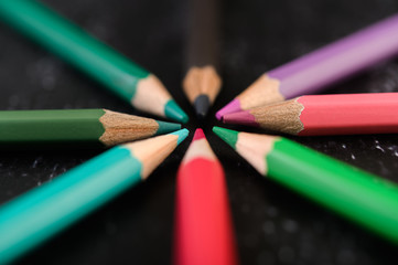 Close-up, wooden crayons arranged in a color wheel.