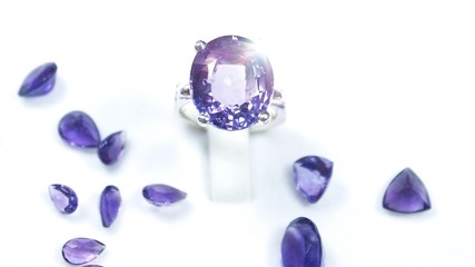 precious gift for your lover. Amethyst gemstone ring and violet or purple loose stone on white background. Gems and Jewellery background       