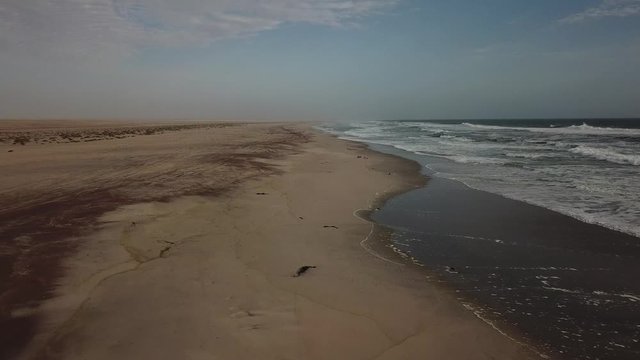4K aerial drone video view of Namibian Atlantic coastline, Zeila L-758 Walvis Bay stranded rusty shipwreck at sand beach in Skeleton Coast Park landscape with ocean background at Namibia's west coast