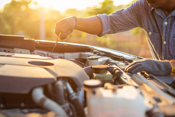 Hand of technician checking or fixing engine of modern car
