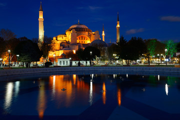 Fototapeta na wymiar Lights on Hagia Sophia at twilight with reflections in fountain Istanbul Turkey
