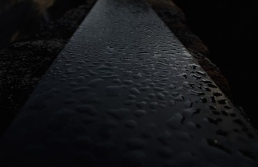 Dew droplets on a dark granite slab at dawn
