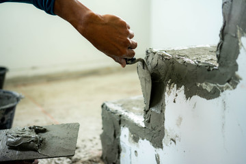 Construction worker with trowel plastering.
