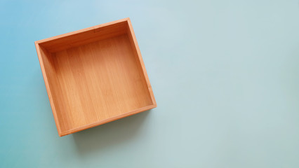 Top view of an empty wooden box on a blue background.