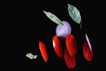 abstract kitchen background with sliced vegetables in a tossed state on a dark background