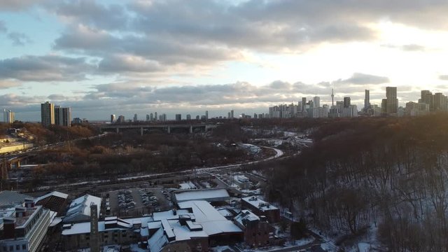 Drone shot of the Toronto skyline from the ravine. The DVP and the evergreen brickworks factory is below.