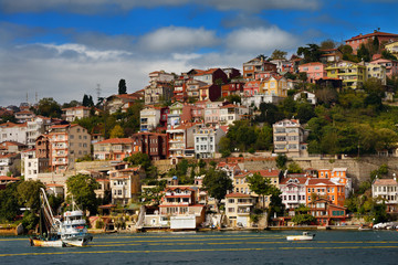Fototapeta na wymiar Purse Seine fishing boat on the Bosphorus Strait with houses on hill at Yeni Mahalle Sariyer Turkey
