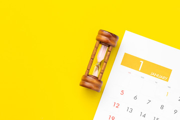 Vintage hourglass or sandglass on new year calendar for planning concept