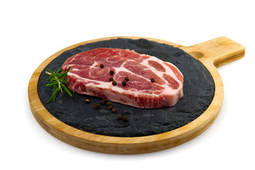 raw pork slices on black stone plate, isolated on white.