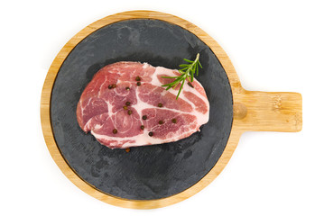 raw pork slices on black stone plate, isolated on white.