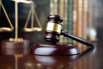 Law and justice theme, judge’s gavel and the scale on court library background
