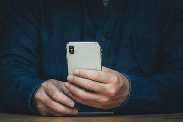 using cell phone.hand holding texting message on screen mobile chatting friend ,search internet information sitting on sofa in office.technology device contact communication connecting people concept