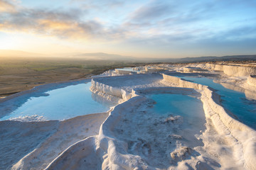 Beautiful sunset and Natural travertine pools and terraces in Pamukkale. Cotton castle in southwestern Turkey near Denizli, Hot springs white colored with turquoise blue water used like a bath