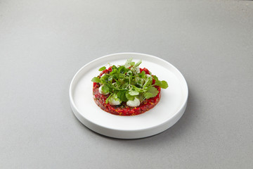 watermelon tartare decorated with mint leaves, herbs, laid out on a plate