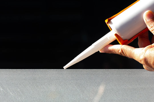 Craftsmen use silicone glue to fix glass work. - Powered by Adobe