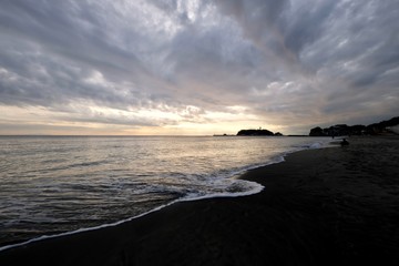 Obraz premium sunset of Enoshima island in Kanagawa Japan. Sea waves against beach. Wide angle