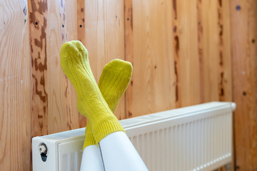 Modern radiator on wooden wall in house with cozy interior