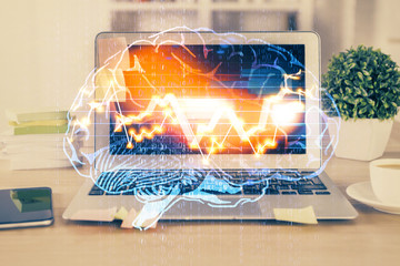 Double exposure of table with computer and brain hologram. Data innovation concept.