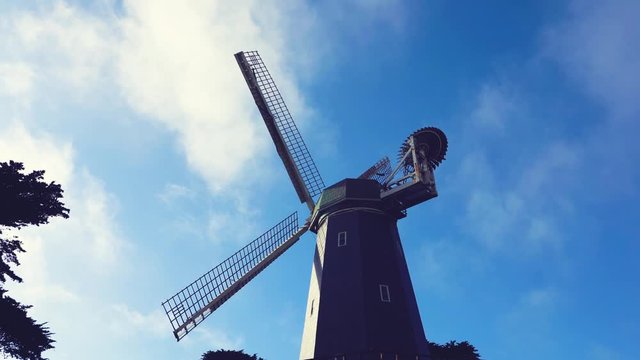 Big mill in the San Francisco city garden in front of a blue cloudscape