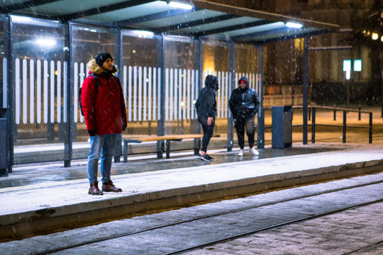 Man At Winter Snowed Night At Railway Station Waiting For Tram