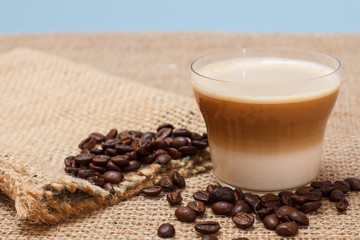 Coffee cappuccino and coffee beans on sackcloth background
