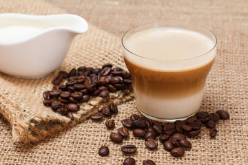 Coffee cappuccino and coffee beans on sackcloth